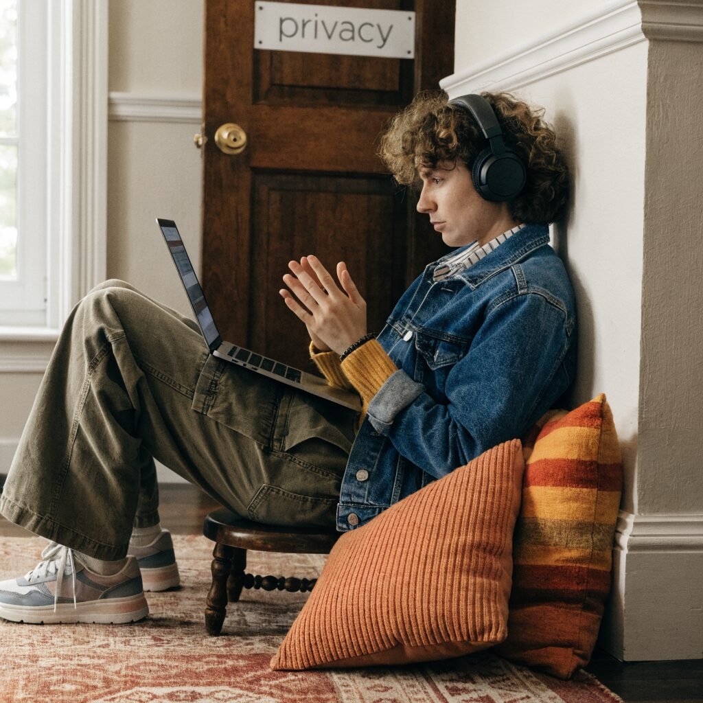 Person attending a private teletherapy session from a comfortable room, wearing headphones for privacy